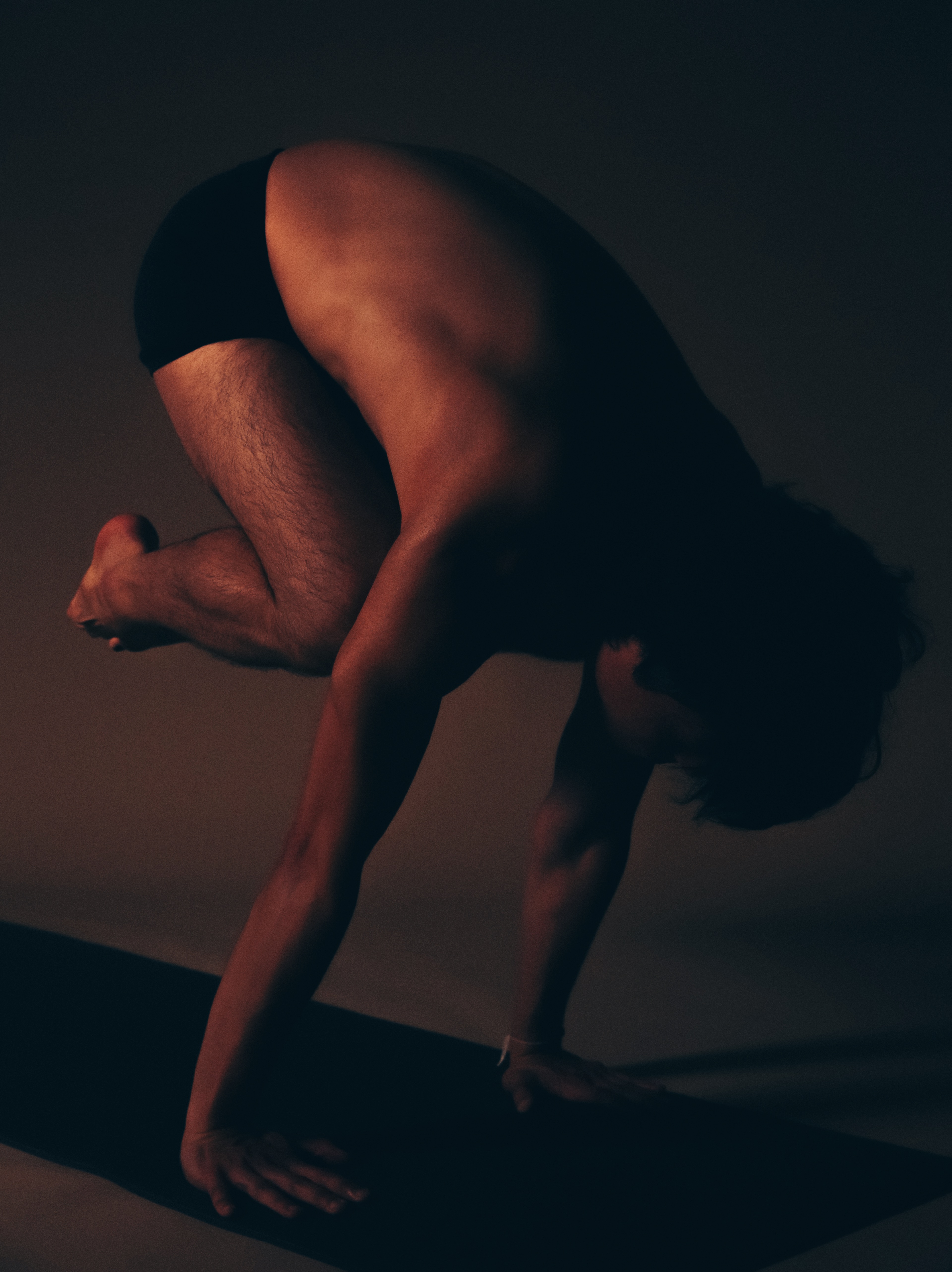 A practitioner in crow pose on a yoga mat