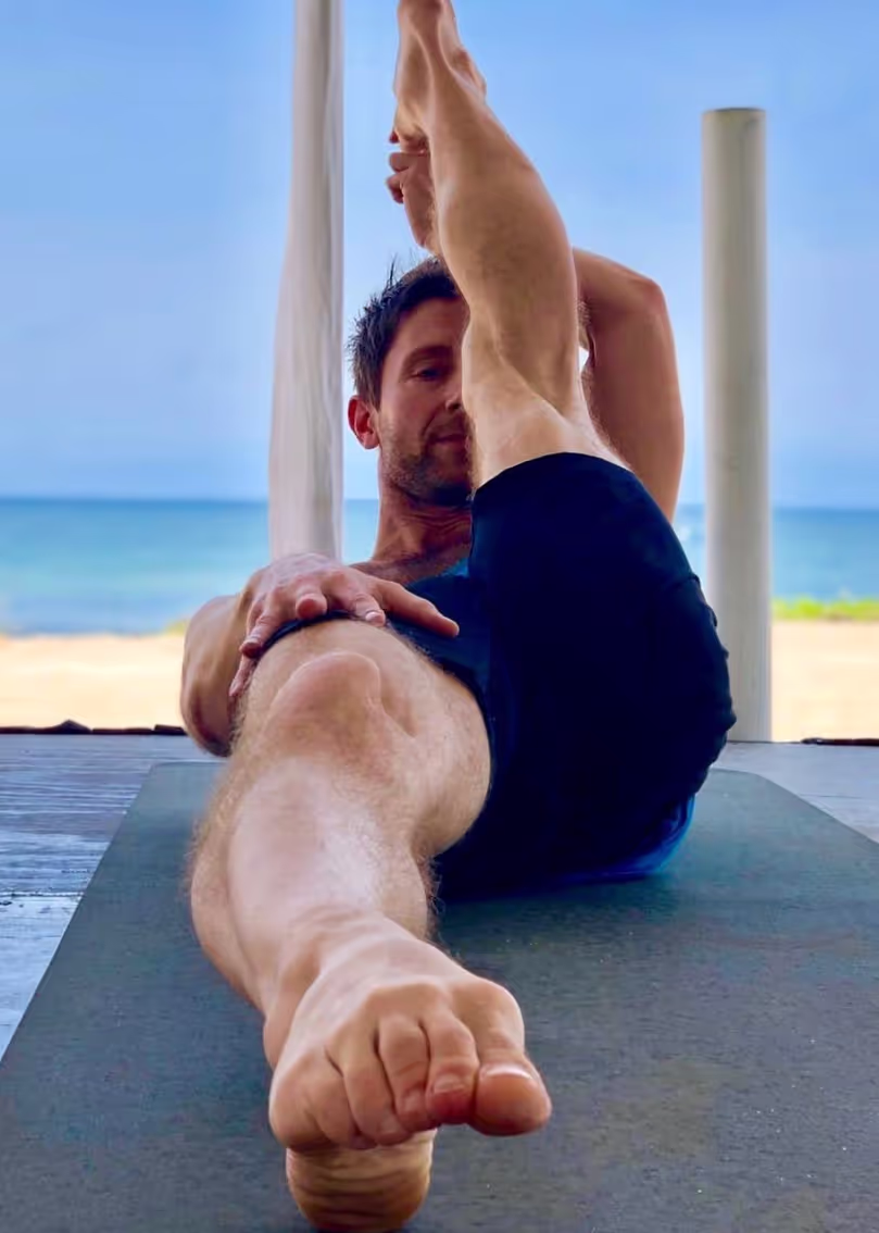 Steve Pyka stretching on a deck by the ocean