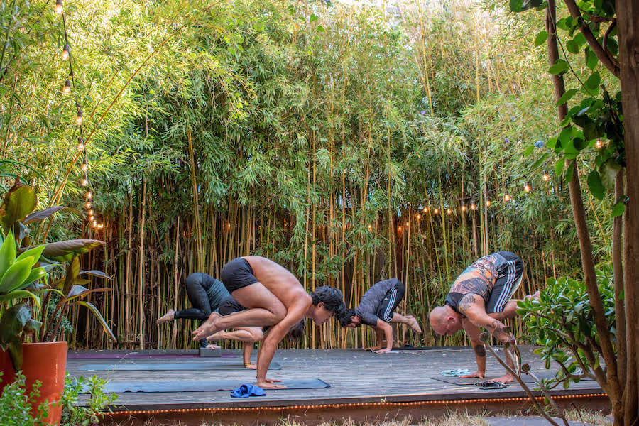 Students practicing crow pose on the garden deck