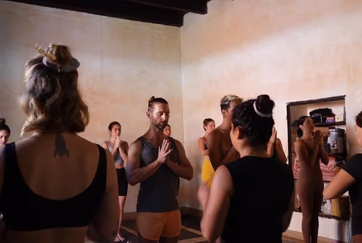 Students gathered with hands at heart in the studio