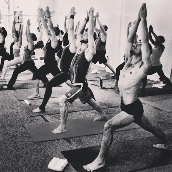 Students in Warrior I during a class at AstaYoga